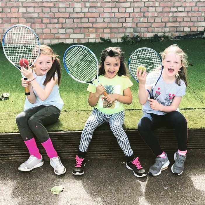 3 young girls holding tennis rackets at Sports Focus UK camp